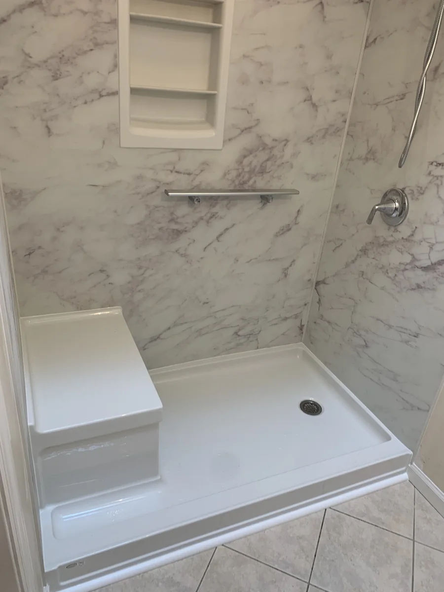 After shower remodel with marble-look wall panels and built-in seat