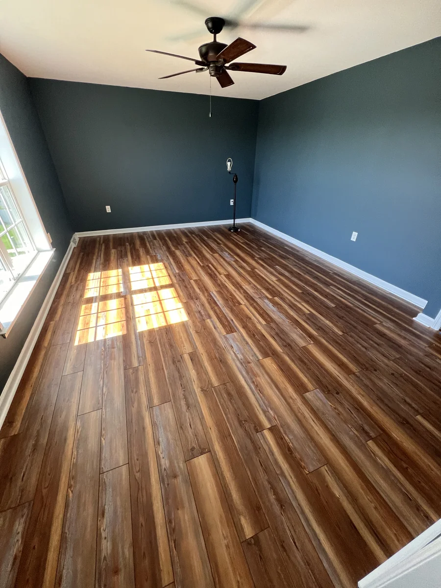 Finished walnut-look laminate flooring in a dark accent wall room