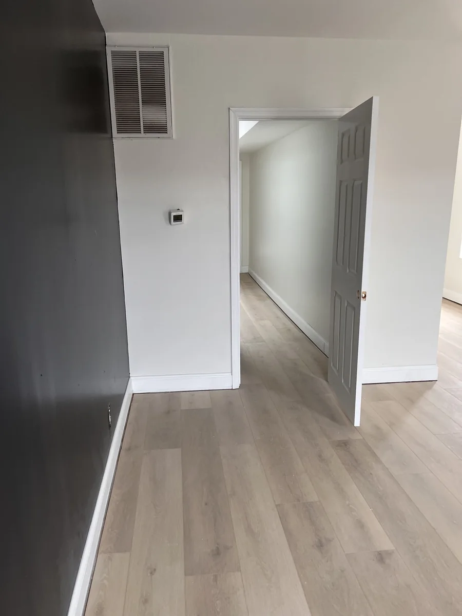 Luxury vinyl plank flooring with black accent wall and white trim