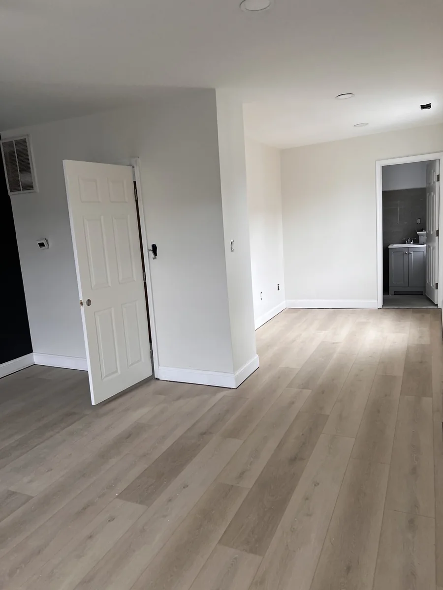 Light beige luxury vinyl plank flooring installed in an open room by PrimeLayer Pro
